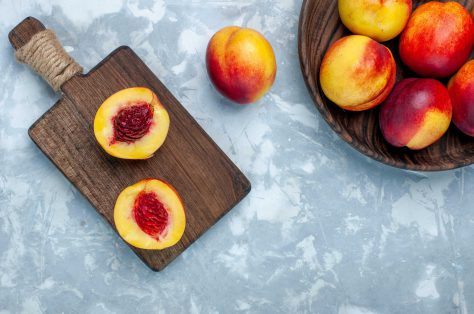 Top view fresh peaches mellow tasty fruits inside brown plate light white desk min