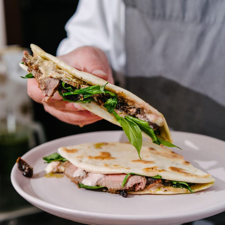 Italian piadina chef39s hands with roast beef wild garlic sundried tomatoes pesto mozzarella bechamel sauce